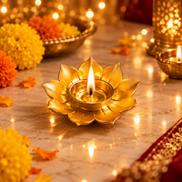 Gold lotus-shaped diya with lit candle